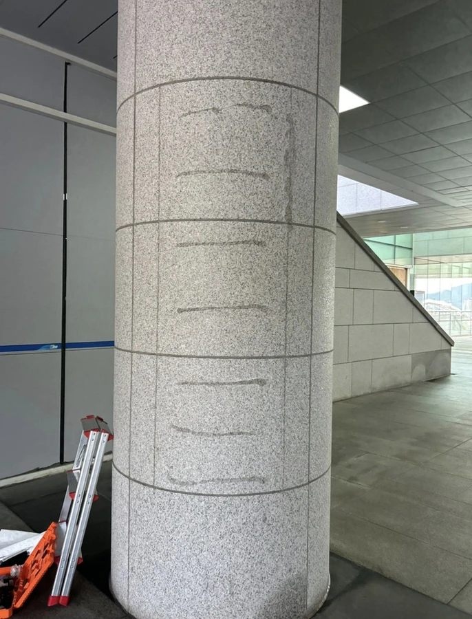 건물 로비 화강석 기둥에 부착물 테두리 자국이 남은 제거 전 현장