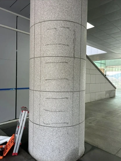 외부 석재 기둥에 광고물을 부착했던 띠 모양 실리콘 자국이 남은 제거 전 현장